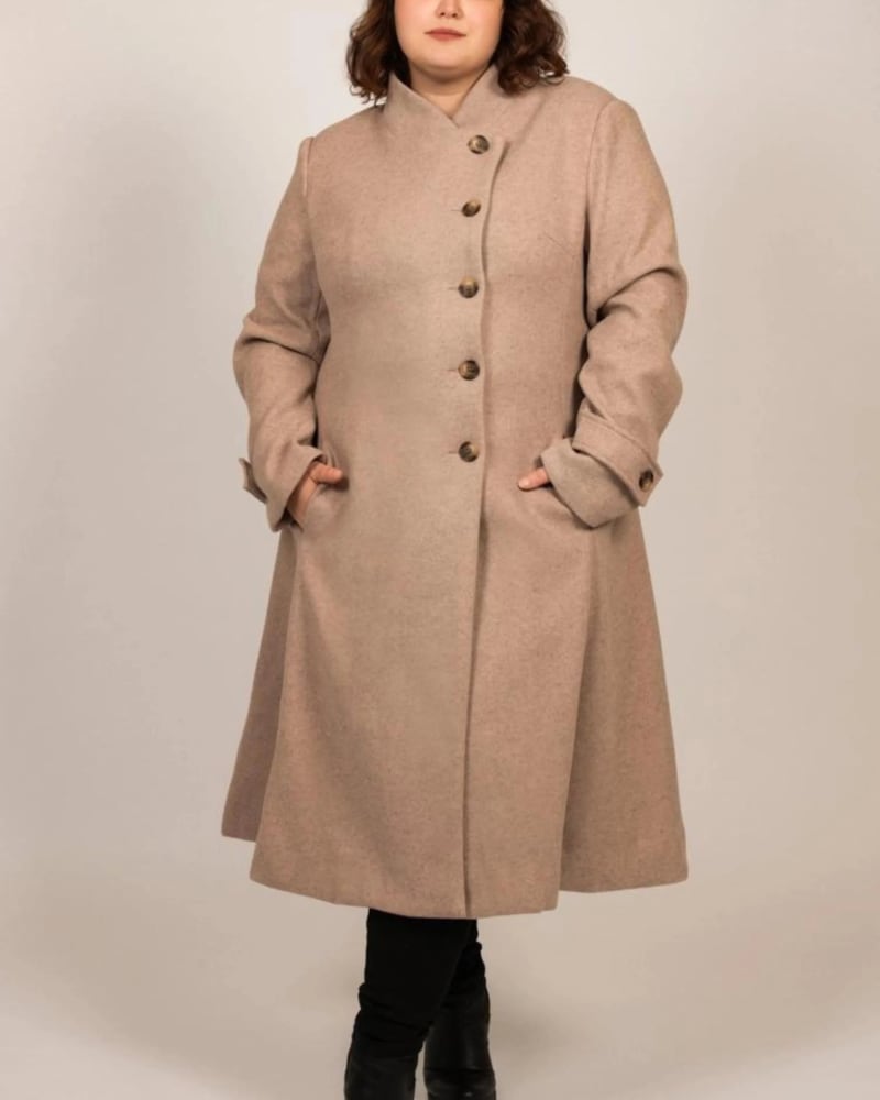 Front of a model wearing a size 2X Harper Retro Flared Coat Side Buttons in Beige by ANNICK. | dia_product_style_image_id:309561
